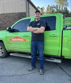 Man wearing a SERVPRO uniform in front of a green background