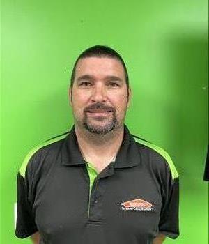 Man on a green background in a SERVPRO shirt