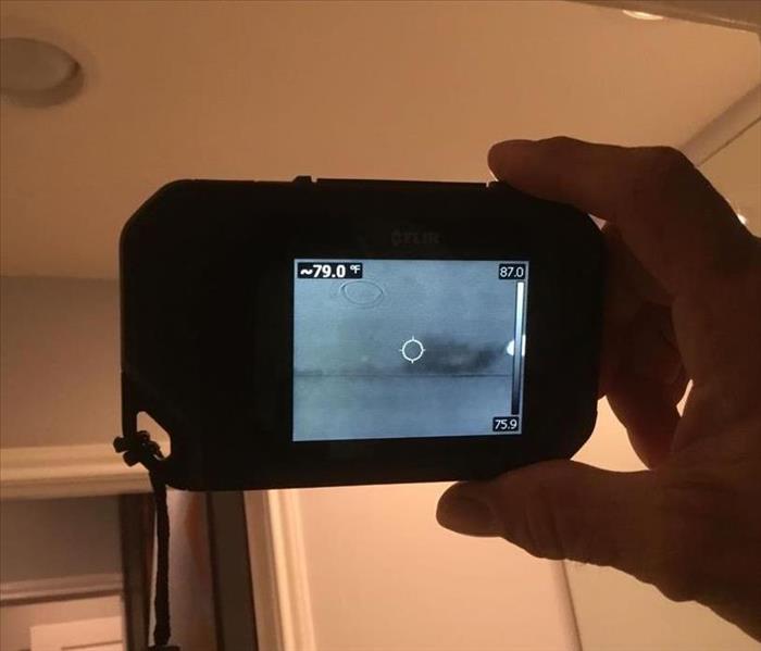 Thermal imaging camera locating a wet spot between ceiling and wall